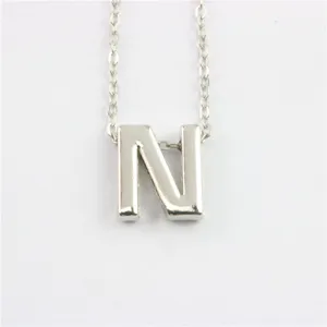 Close-up van een zilveren letter N hanger ketting met prachtig fijn schakelkettingontwerp.