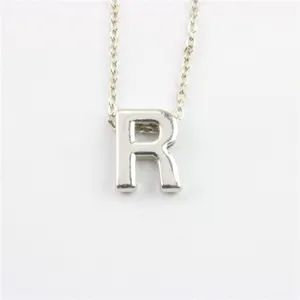 Detailopname zilveren letter R hanger, fijne metalen ketting, minimalistisch sieraad.