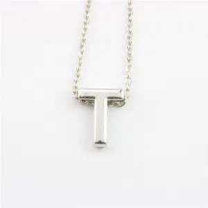 Gedetailleerd opname van een zilverkleurige letter T hanger ketting, eenvoudig sieraad.