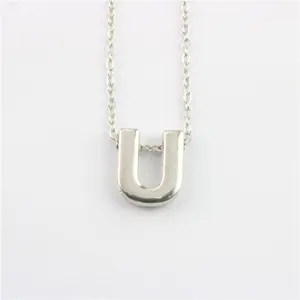 Zilveren ketting met letter U hanger, gedetailleerde close-up van minimalistisch accessoire.