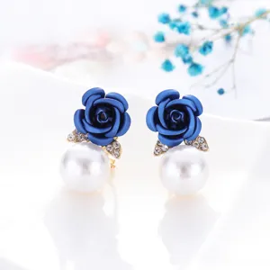 Detailopname van elegante blauwe roos oorbellen versierd met parels en fonkelende strass.