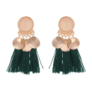 Detailed view of bohemian style alloy earrings with frosted metallic discs and green tassels.