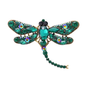 Gedetailleerd overzicht van de sprankelende groene strass libel broche, elegante mode speld.