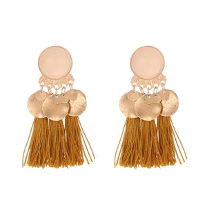 Detail view of the alloy matte round disc and tassel earrings, bohemian style chic.