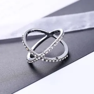 Zilverkleurige crossover ring gedetailleerd met sprankelende pavé kristallen in modern open.
