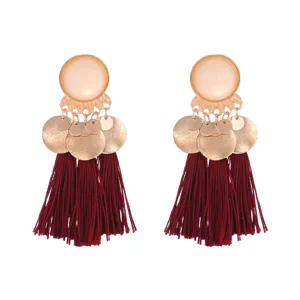 Close-up detail of bohemian burgundy tassel earrings with gold alloy frosted round discs.
