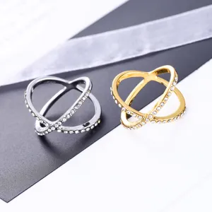 Gedetailleerd uitzicht van verweven strass gekruiste ringen in zilver en goud afwerking.