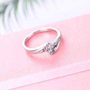 Gedetailleerde close-up van een zilverkleurige ring met elegant design en fonkelende steentjes.