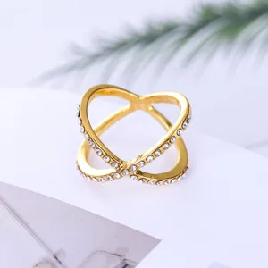 Close-up detail van gouden kruis strass ring met fonkelende kristallen steentjes.