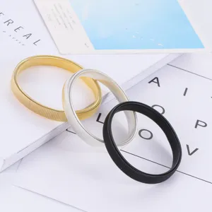Σετ από ελαστικά μεταλλικά βραχιόλια σε χρυσό, ασημί και μαύρο χρώμα, λεπτομέρεια.