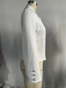 Detalle lateral de una chaqueta blazer corta blanca para mujer con botones en manga.