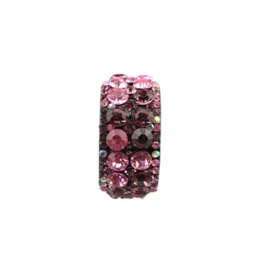 Close-up detail of a sparkling rhinestone ponytail holder featuring pink and purple crystals.