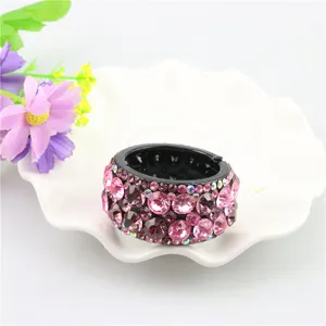 Detailed shot of a gorgeous rhinestone hair bun maker, sparkling pink crystals on black base.