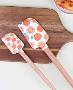 Vue détaillée de la spatule en silicone avec motif d'orange et manche en bois.