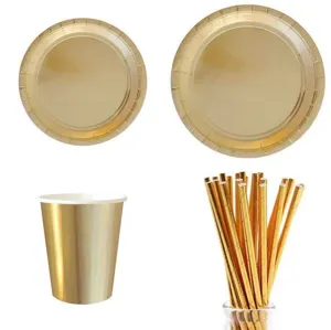 Gold disposable party tableware set including paper plates, cups and straws for birthdays.
