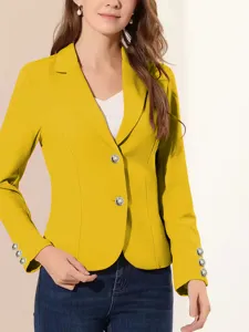 Detalle de blazer ajustado amarillo para mujer, con elegantes botones metálicos y mangas.