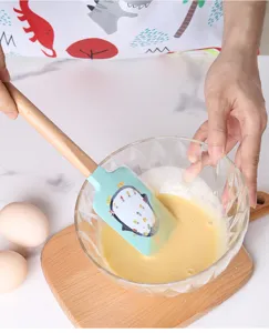 Silicone baking spatula with wooden handle for cake cream mixing and kitchen cooking.