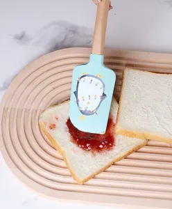 Detail view of silicone spatula with wooden handle, cute penguin design for baking and spreading.