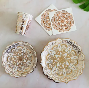 Detailed view of rose gold foil mandala paper plates cups and napkins for party decor.