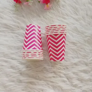 Close-up detail of pink and white chevron paper cups on furry background, party tableware decor.