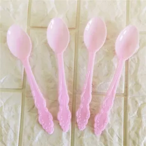 Vista detallada de cucharas de postre de plastico rosa, ideales para tartas y fiestas.