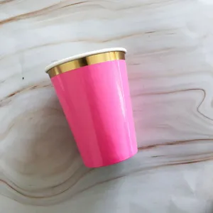Close-up detail of the pink and gold disposable paper cup, showing textured paper rim.