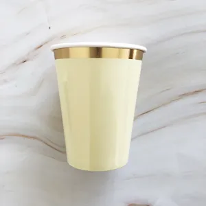 Disposable paper cup detail shot, light yellow body with metallic gold rim, eco-friendly.