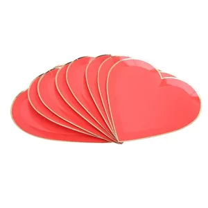 Red heart-shaped paper plates with gold rim, disposable party tableware for Valentine's day.