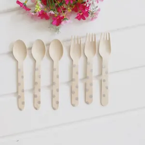 Close-up detail of disposable wooden cutlery, featuring cute polka dot patterns on spoons and forks.