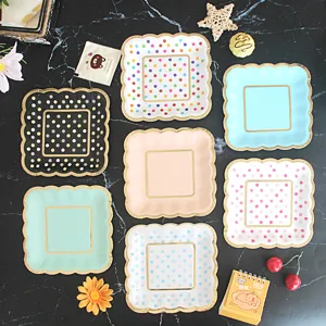Disposable square paper plates with colorful polka dots and gold foil edges for cakes.
