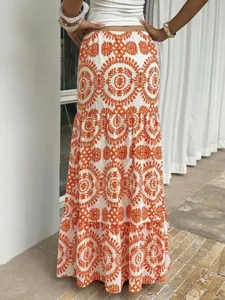 Bohemian long tiered skirt with intricate orange embroidery details, perfect for summer beach.