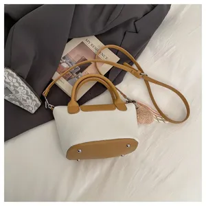 Stylish white and brown leather top handle crossbody bucket bag with adjustable strap.