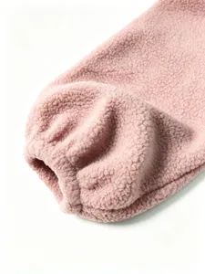 Pink sherpa fleece jacket sleeve detail, soft cozy fuzzy winter warm outerwear closeup.