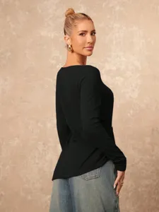 Detail view of women's black long sleeve top featuring irregular metal buckle and side slit.