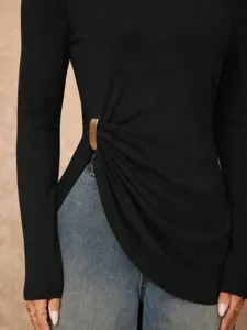 Close-up of stylish black long sleeve top with irregular metal buckle and side slit detail.