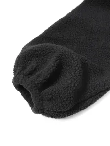 Black sherpa fleece jacket sleeve detail close-up, warm cuffed winter outerwear design fabric.