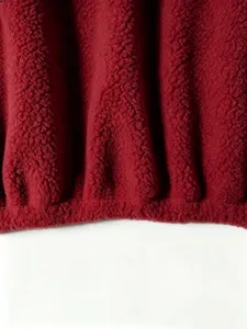 Red fleece jacket fabric texture detail, soft sherpa material close up, cozy winter apparel.