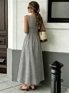 Chic black and white gingham sleeveless maxi dress with smocked waist for summer wear.