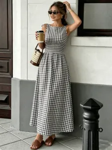 Detailed view of a stylish black and white gingham sleeveless midi dress featuring a smocked waist.