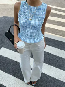 Primo piano del top a quadri vichy blu e bianco con dettagli smockati e texture definita.