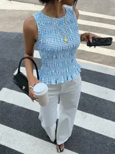 Dettaglio del top a quadri blu e bianco smockato senza maniche, elegante vestibilità slim estiva chic.
