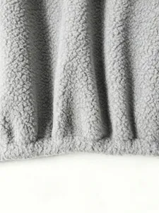 Close-up detail of soft gray sherpa fleece fabric showing warm texture and cozy material.