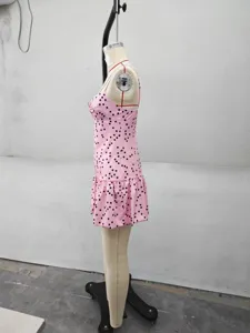 Vue de détail de la mini-robe nuisette à pois rose avec ourlet à volants et détail en métal.