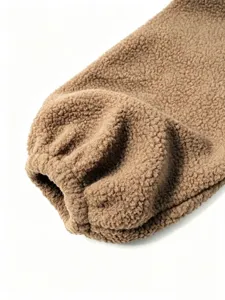 Detail shot of brown fluffy fleece shearling jacket sleeve with elastic cuff texture.