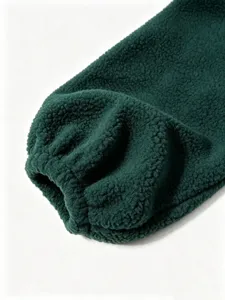 Dark green fleece jacket sleeve close-up, soft lamb wool fabric detail, cozy winter apparel.