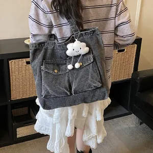 Detail view of the stylish grey denim tote bag featuring multi pockets and cute cloud charm.