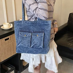 Denim tote bag detail showing dual front pockets and durable washed fabric construction.