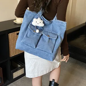 Casual denim tote bag with dual front pockets and cute cloud charm, perfect for daily use.