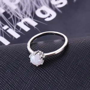 Minimalist silver opal ring with four-prong setting, elegant gemstone detail shot.