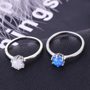 Opal gemstone ring detail view, elegant minimalist silver ring with white and blue opal stones.